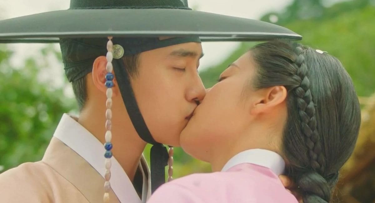 Atores Do Kyung-soo (D.O.) de chapéu tradicional coreano e Nam Ji-hyun de trança se beijando em cena romântica de 100 Days My Prince.